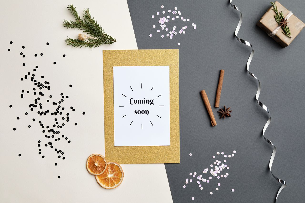 A festive holiday-themed flat lay featuring a 'Coming Soon' greeting card with decorative elements.